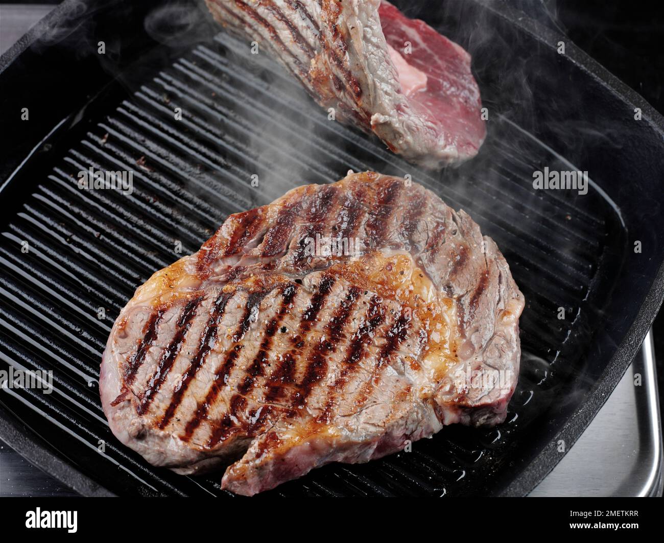 Ich drehe das Rindfleisch in einer Kirschgrillpfanne Stockfoto