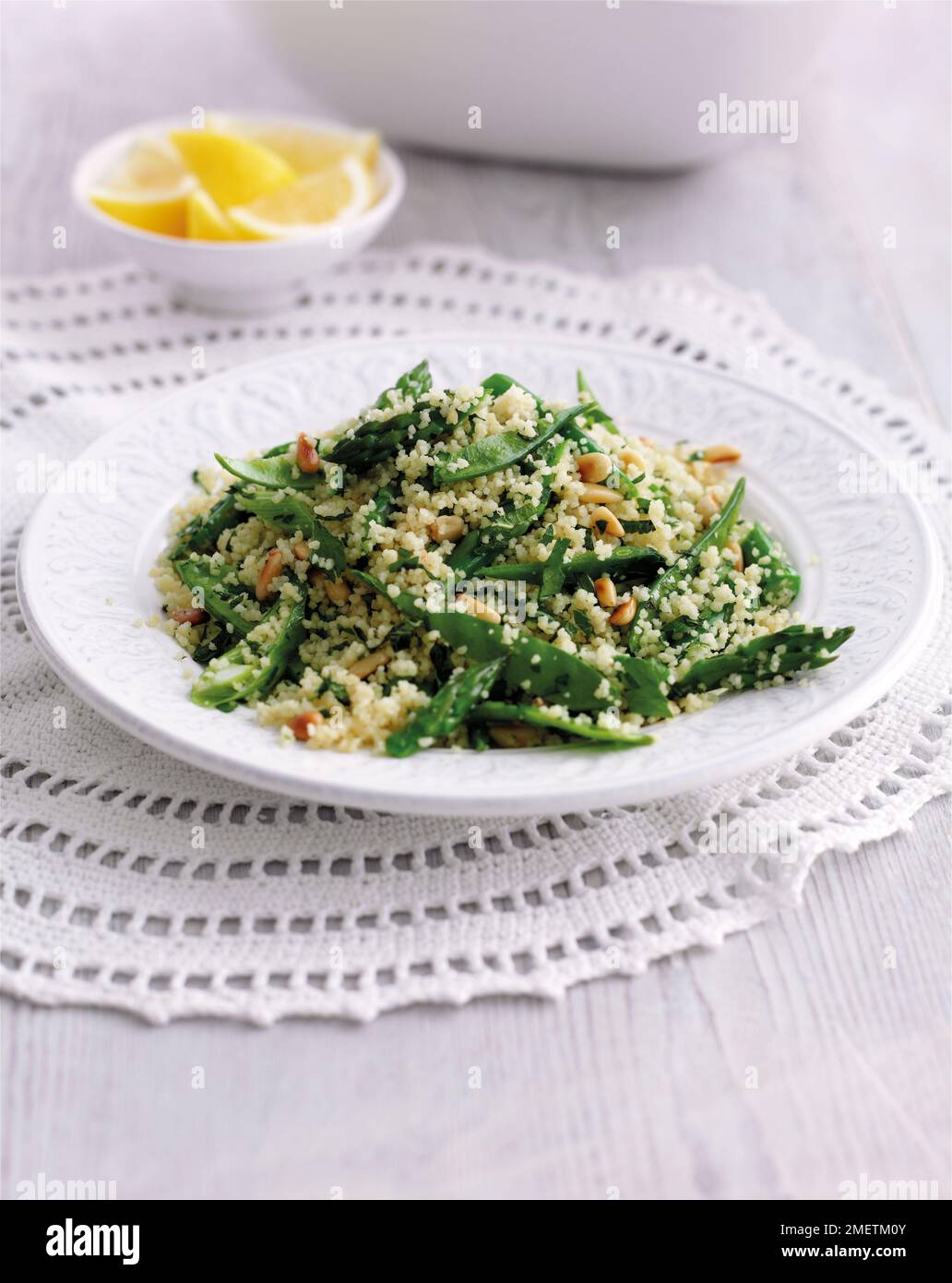 Gemüse-Couscous mit Mangetouts, Spargel, Pinienkernen, Kräutern und Zitrone Stockfoto