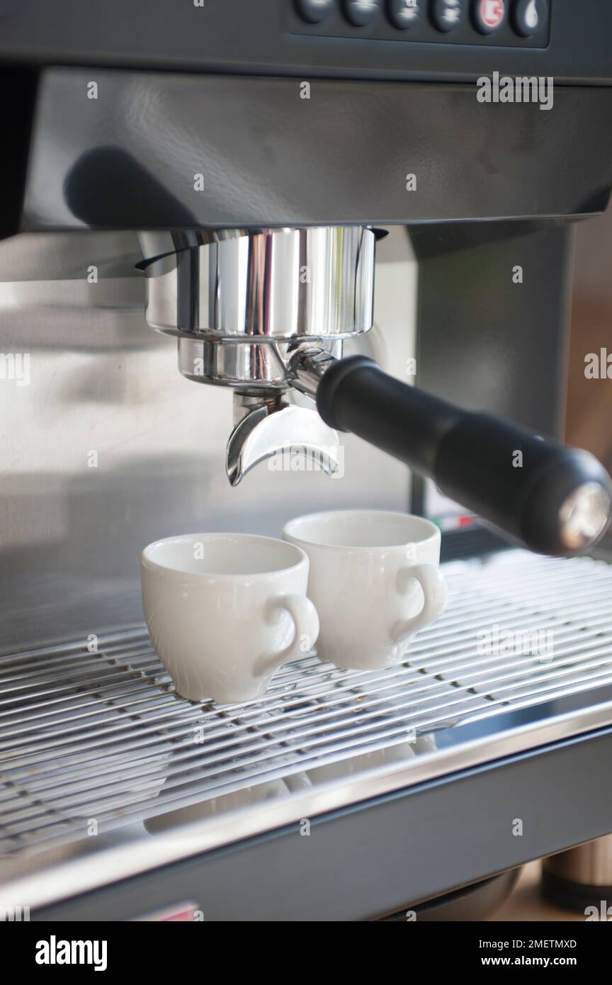 Zwei Espressobecher unter den Kaffeeauslauf der Espressomaschine Stockfoto