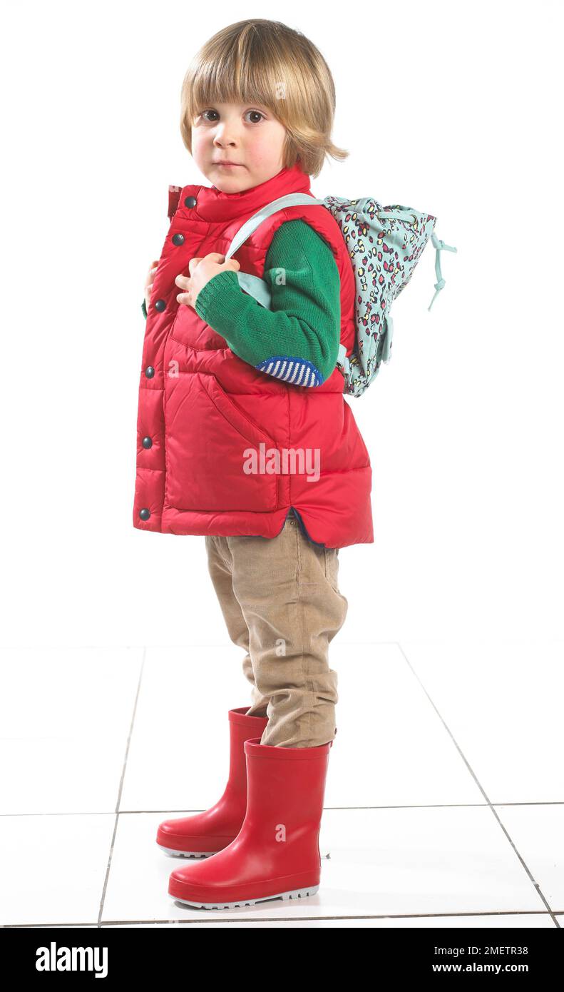 Ein Junge (3 Jahre) trägt Outdoor-Kleidung und einen Rucksack Stockfoto