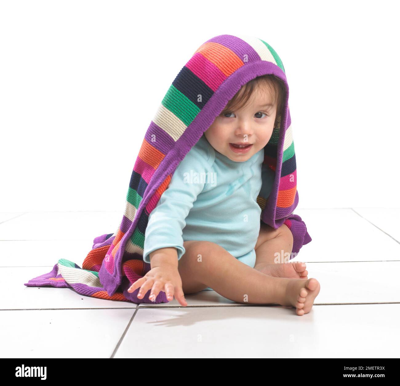 Kleinkind Jungen mit bunt gestreifte Decke auf den Kopf Stockfoto