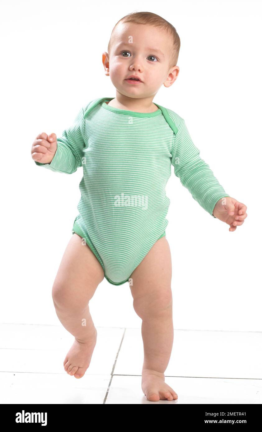 Babyjunge (12,5 Monate), der auf einem Bein steht Stockfoto