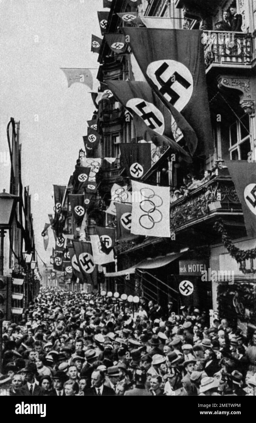 Menschenmassen auf den Hauptstraßen, Flaggen, Hakenkreuze Stockfoto