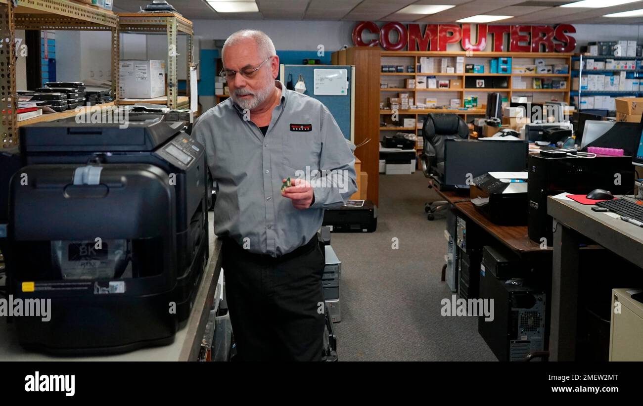 Independent repair shop owner Curtis Jones works on an Epson printer at
