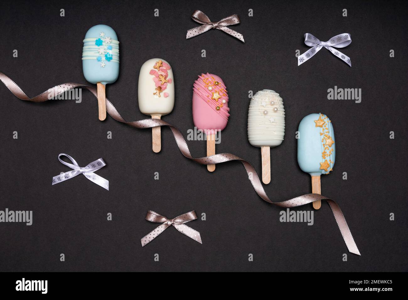 Ansicht von oben auf dekorierten Kuchen knallt Eis auf schwarzem Hintergrund Stockfoto