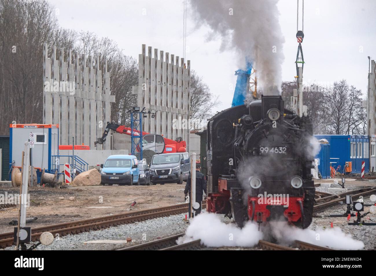 24. Januar 2023, Mecklenburg-Vorpommern, Putbus: Die Dampflokomotive 99 4632 der kleinen Eisenbahn „Rasender Roland“ fährt durch den Bahnhof in Putbus auf der Insel Rügen. Im Hintergrund wird ein neues Depot gebaut. Das Projekt „Railroad Experience Landscape“ umfasst den Bau eines neuen Schuppens und einer Betriebswerkstatt sowie einen Wasserturm für den Betrieb der Dampflokomotiven auf der Grundlage eines historischen Modells. Das Projekt „Railroad Experience Landscape“ hat ein Gesamtinvestitionsvolumen von über 40 Millionen Euro. Sie wird vom Bezirk Vorpommern-Rügen tog umgesetzt Stockfoto