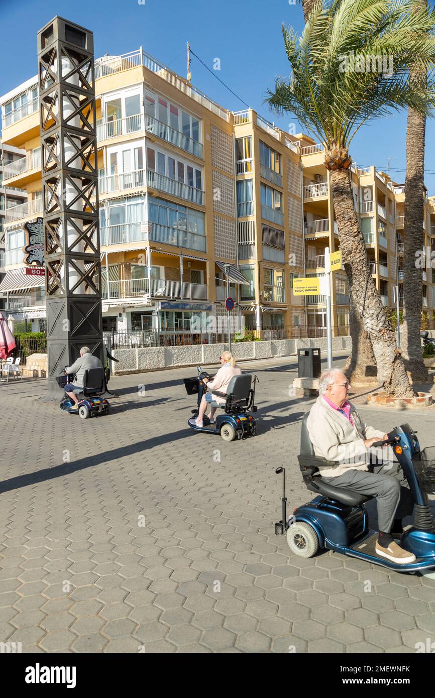 Menschen, die Mobilitätsroller auf der promenade von benidorm benutzen Stockfoto