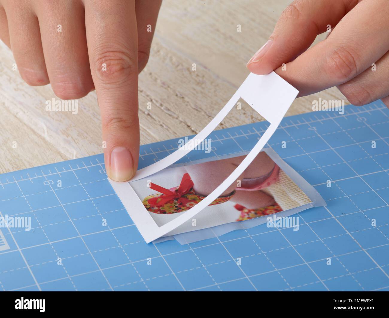 Papierhandwerk. DIY-Bilderrahmen, Schritt 3. Legen Sie den Rahmen über die Oberseite des Fotos Stockfoto