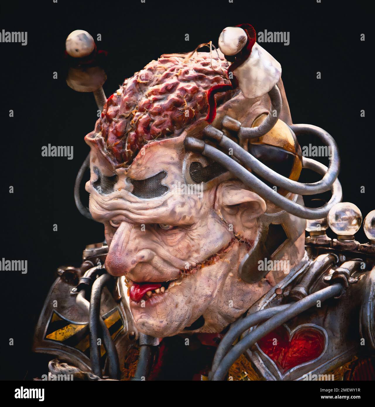 Nahaufnahme eines gruselig aussehenden Außerirdischen oder Mutanten mit seinem Gehirn und einem Narbengesicht in futuristischer Kleidung. Stockfoto