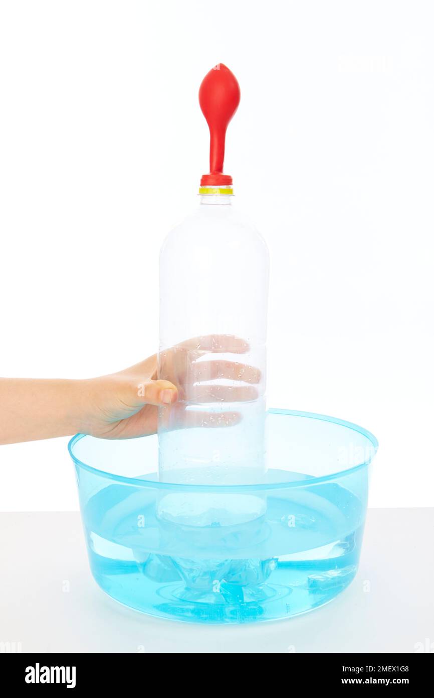 Plastikflasche mit rotem Ballon über der Oberseite in einem Wasserbehälter Stockfoto
