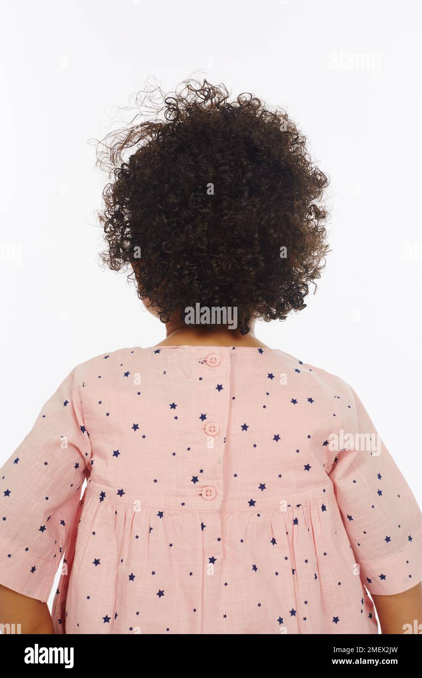 Kleines Mädchen lockiges braunes Haar (Modellalter – 19 Monate) Stockfoto