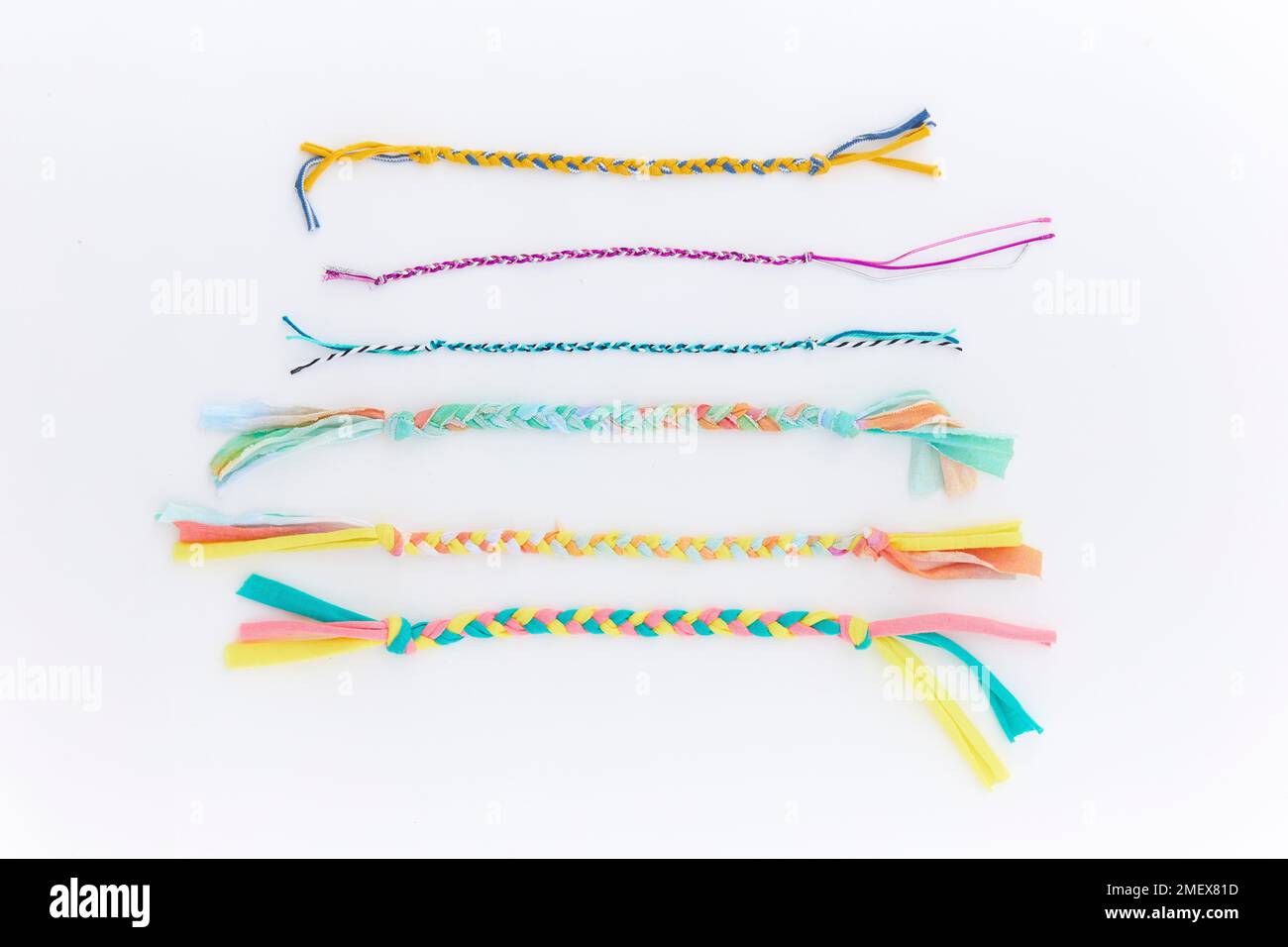 Gewebte Armreifen – geflochtene Armbänder aus verschiedenen recycelten Materialien wie Elastikmaterial, Schnüre und T-Shirt-Stoff Stockfoto