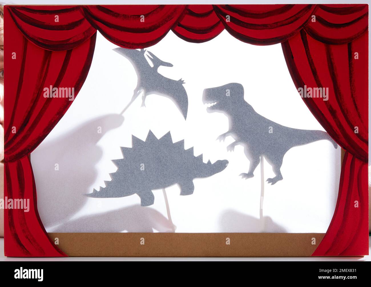 Schauspiel mit Schattenpuppen - Dinosaurierschatten mit Händen Stockfoto