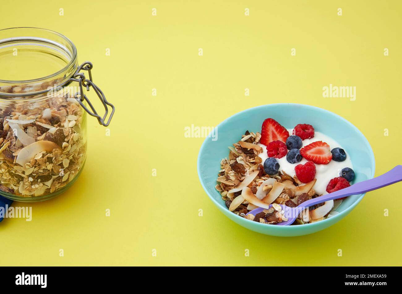 Kein Müsli, keine Schüssel mit Joghurt und Beeren auf gelbem Hintergrund Stockfoto