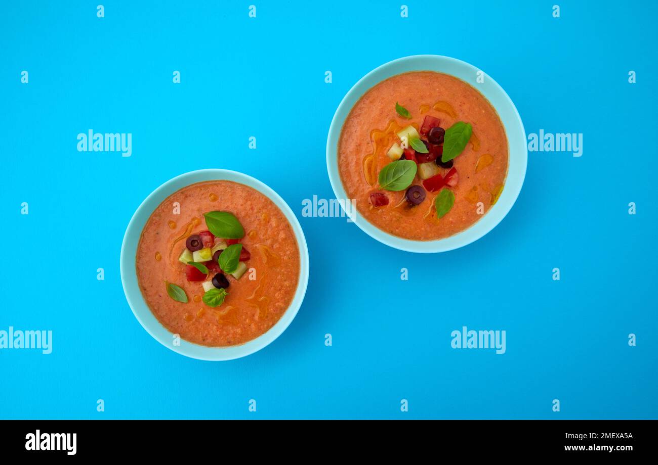 Schalen Gazpacho-Suppe über dem Kopf auf blauem Hintergrund Stockfoto