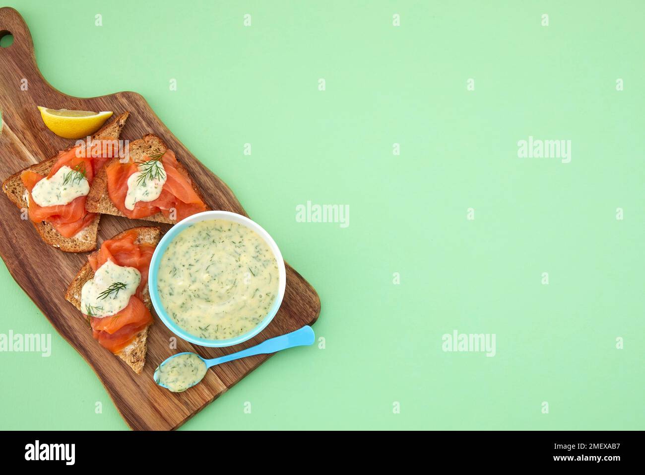 Süßer Senf und Dill Dip, serviert auf dem Schneidebrett mit Lachs auf Brot Stockfoto