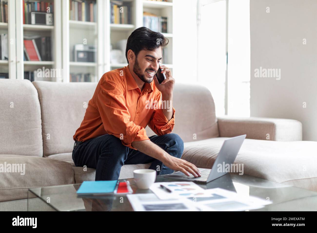 Reicher arabischer Geschäftsmann, der von zu Hause aus arbeitet und ein Notebook benutzt Stockfoto