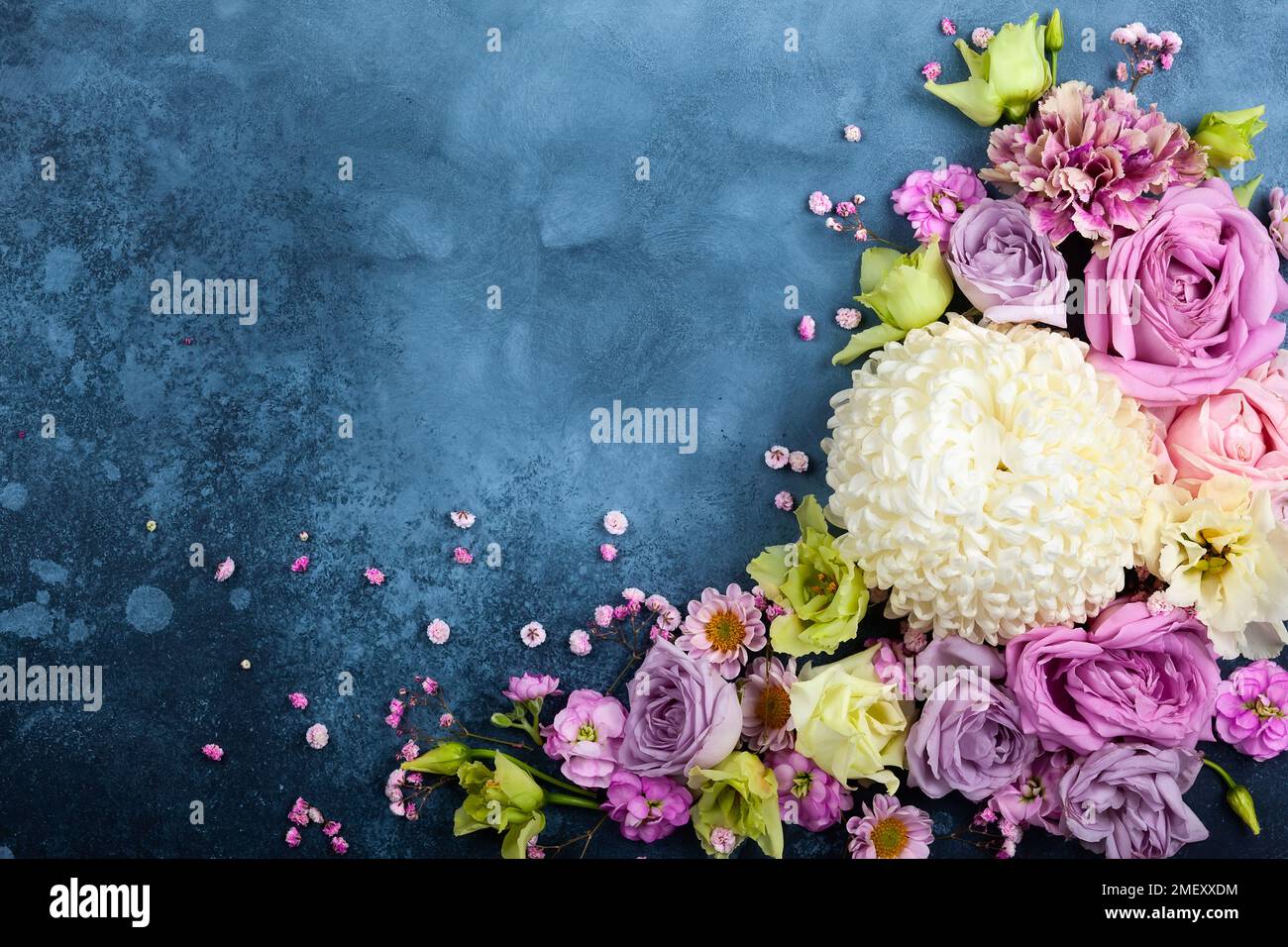 Wunderschöne Blumen auf altblauem Hintergrund. Festliches Blumenkonzept mit sauberem Textbereich. Draufsicht. Stockfoto