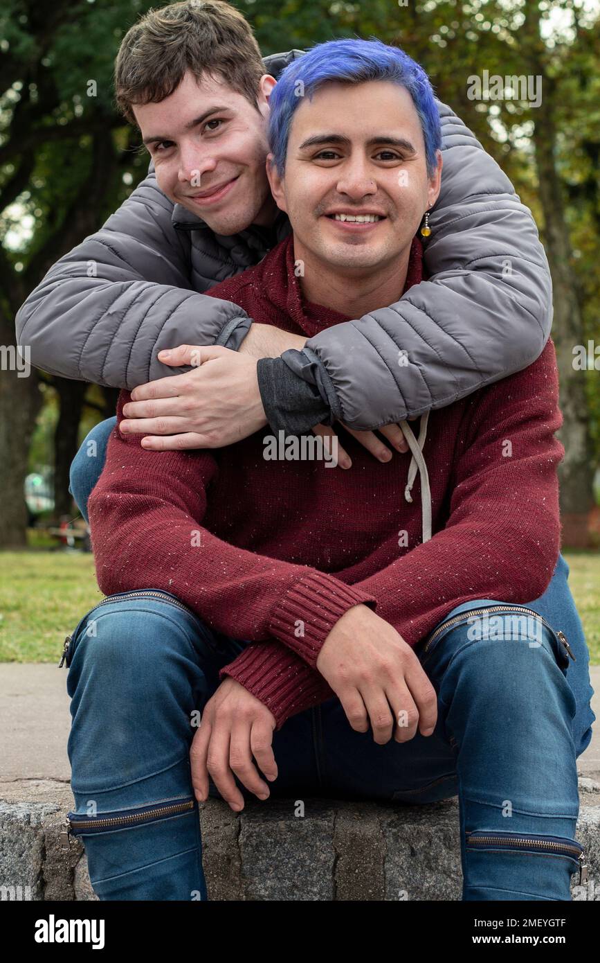 Gay männliche paar umarmt und Blick auf Kamera im Freien Stockfoto