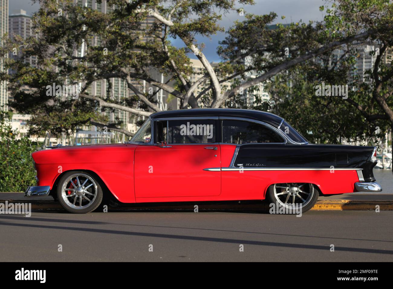 Honolulu, HI - 3. Januar 2023: Das rechte Seitenprofil des wunderschön restaurierten klassischen 1950er Chevy Belair 2-Türers in Rot und Schwarz Stockfoto