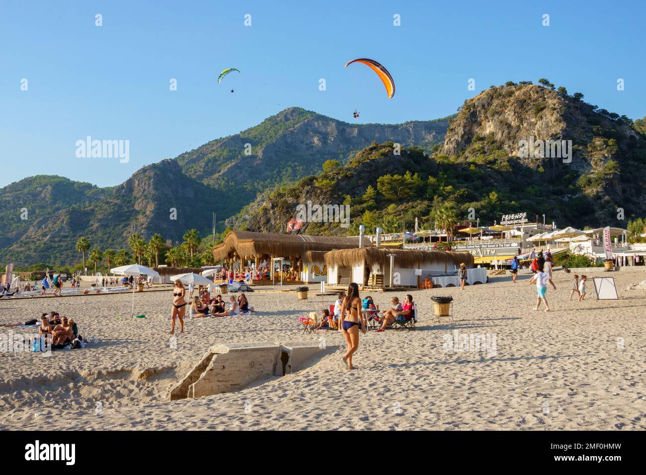 Strandbesucher und Gleitschirmfahrer in Belcekiz Beach, Oludeniz, Fethiye, Türkei Stockfoto