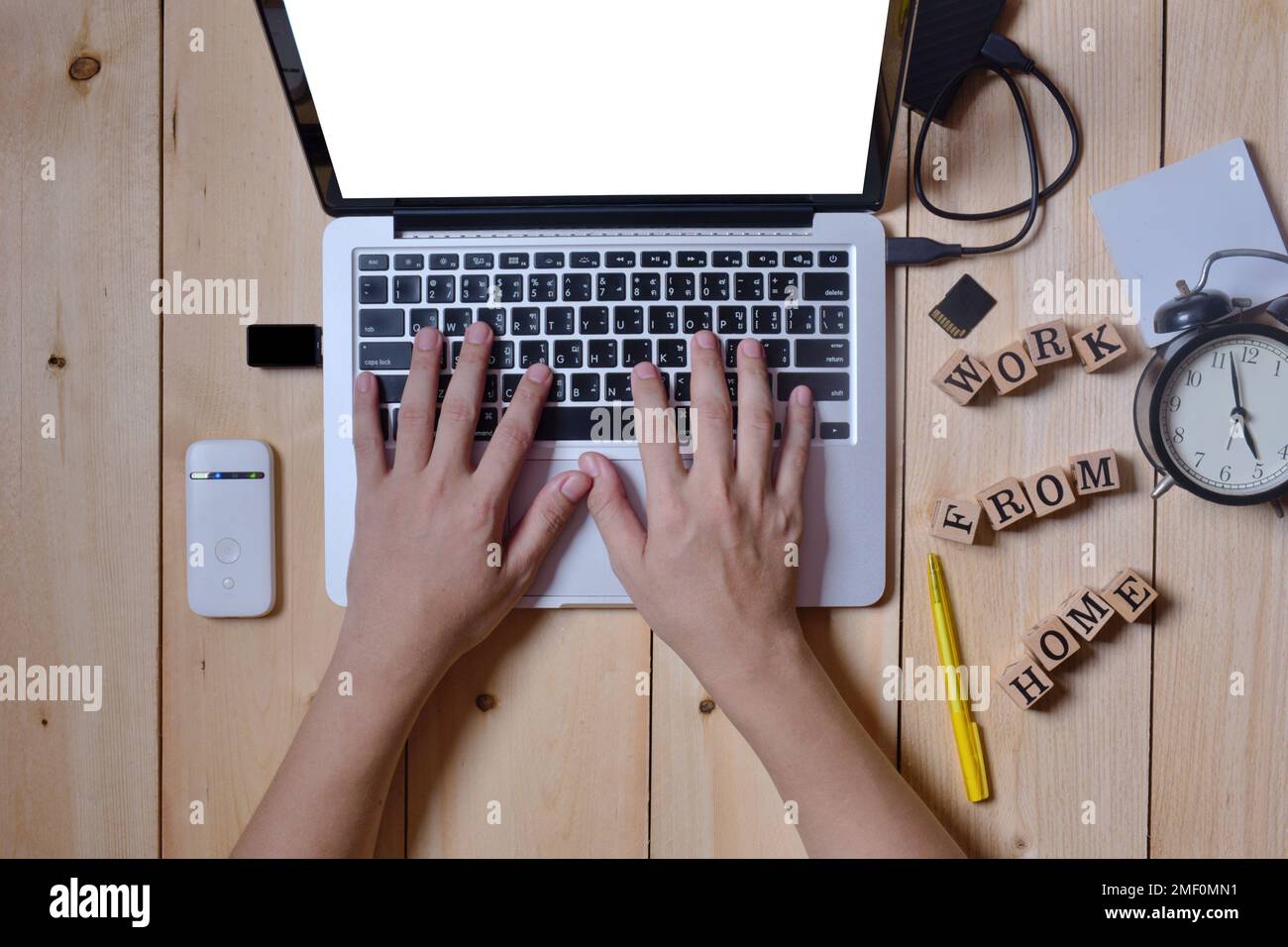 Nahaufnahme Hände Mann, der Tastatur auf Computer Laptop tragbar für die Arbeit zu Hause mit Hardware Zubehör auf Holztisch Stockfoto