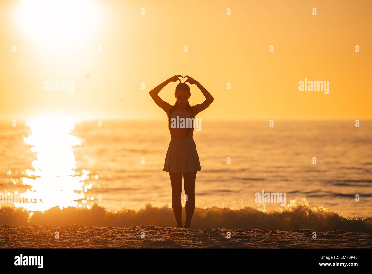 Glückliches Teenager-Mädchen genießen tropischen Strandurlaub bei Sonnenuntergang Stockfoto