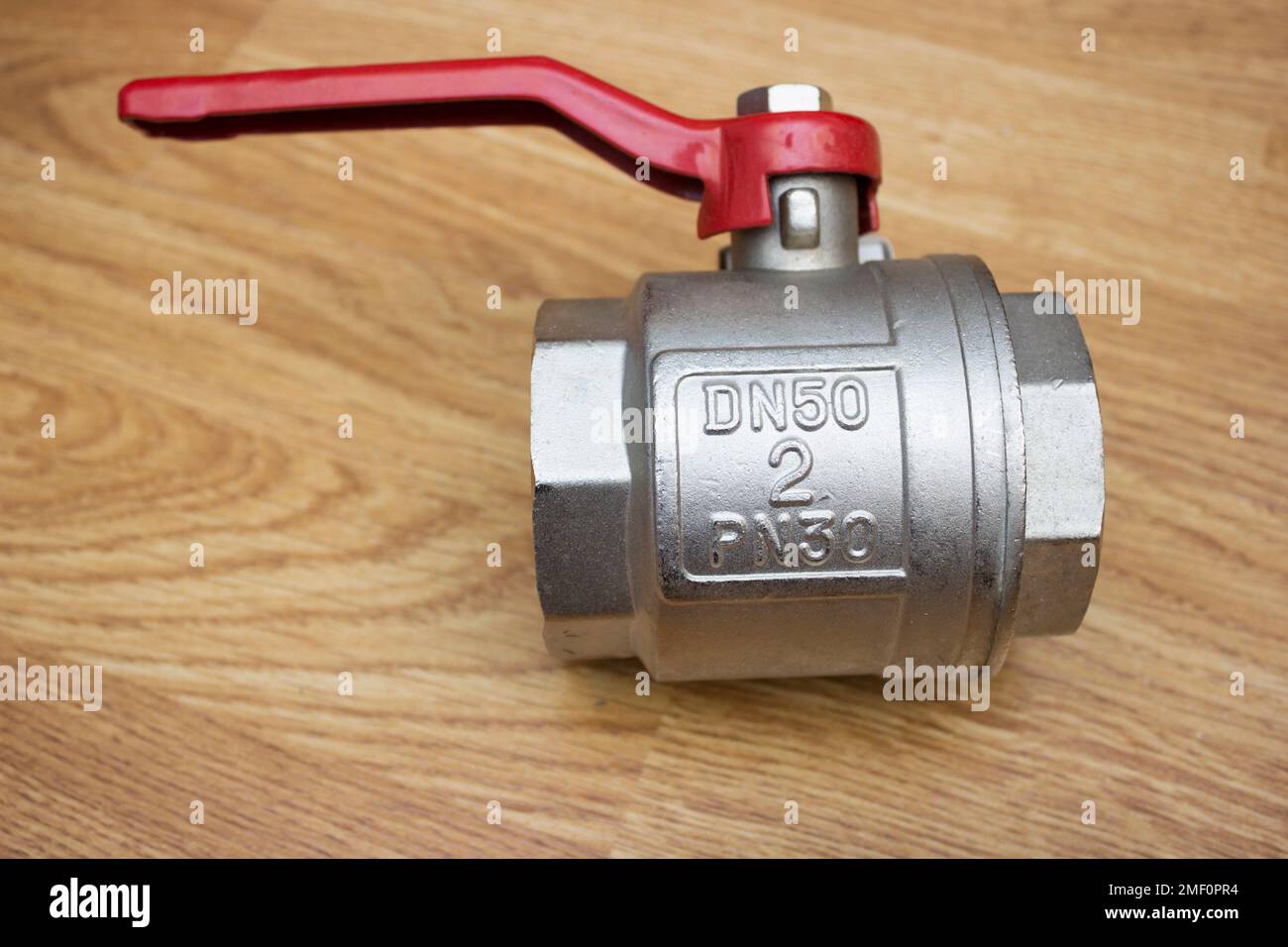 Großer 2'-Kugelhahn mit rotem Hebelgriff für Bodenoberfläche Stockfoto