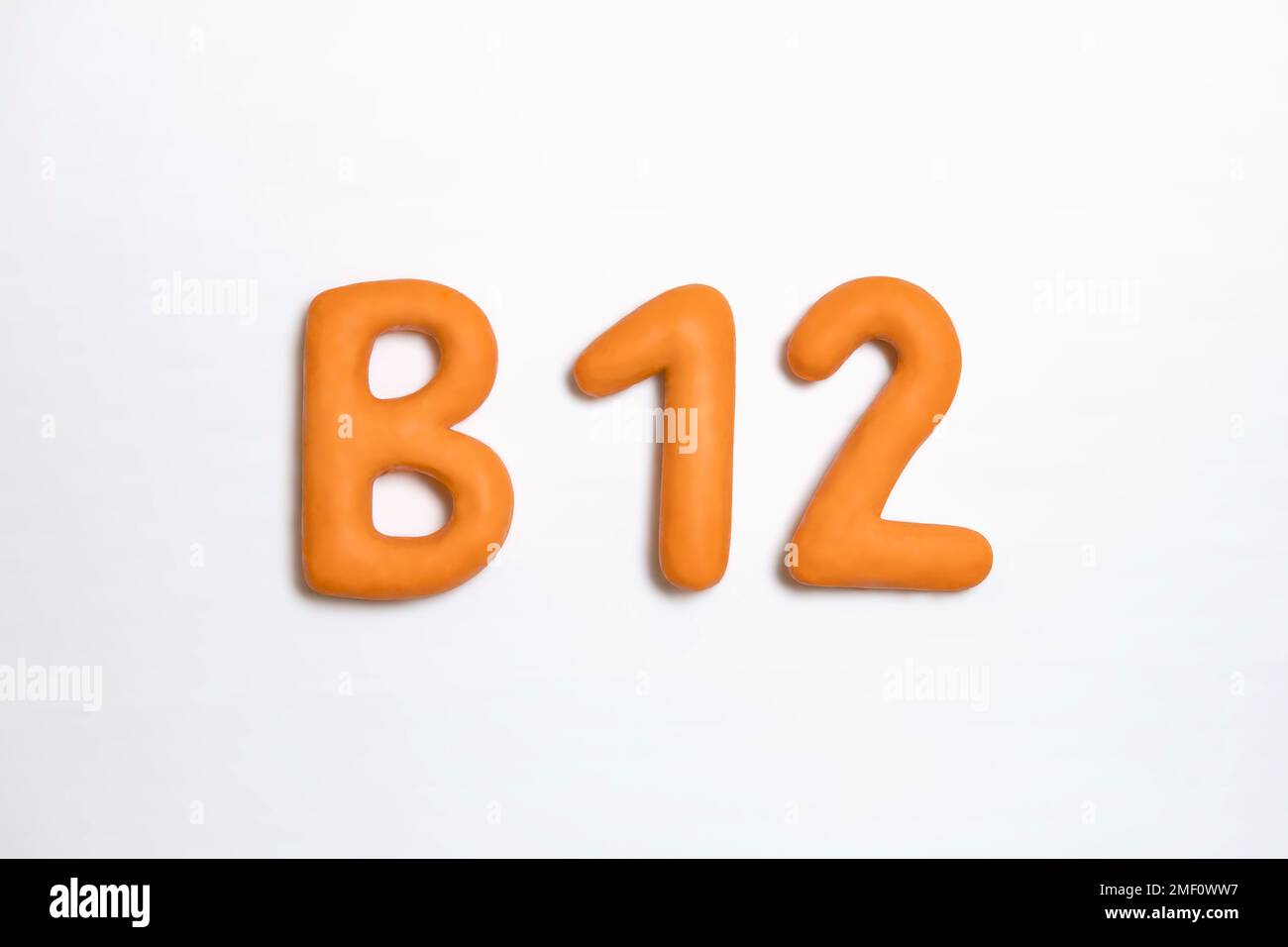 Vitamin-B12-Supplementierungskonzept. Orange Farbe des dreidimensionalen Zeichens auf weißem Hintergrund. Das Kobalamin-Symbol ist wichtig für die Unterstützung der Gesundheit und von V Stockfoto