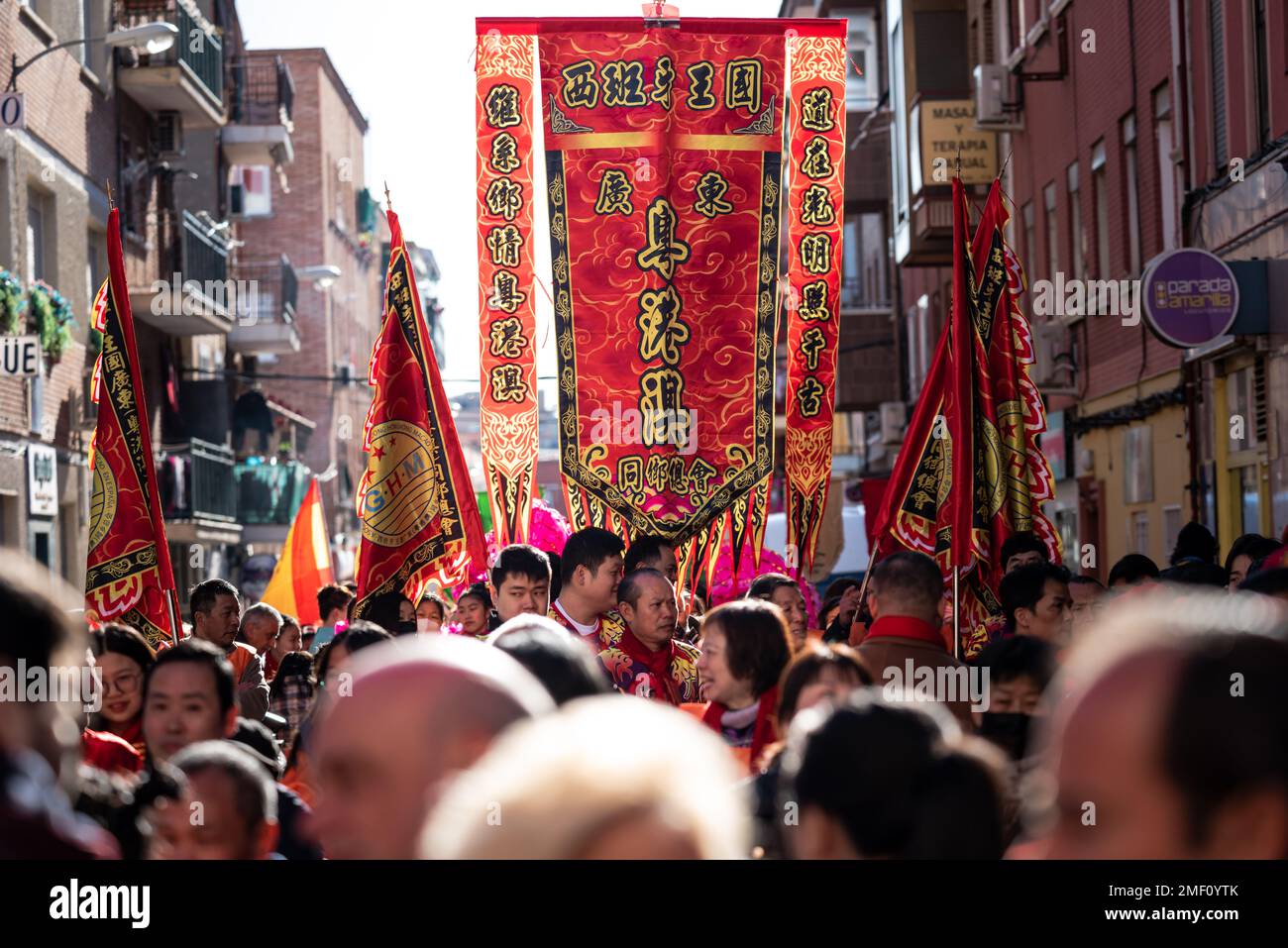 Madrid, Spanien; 22. Januar 2023: Leiter der Parade mit Flaggen mit Symbolen für das chinesische Neujahr im Stadtviertel Usera, Madrid. Spanien Stockfoto