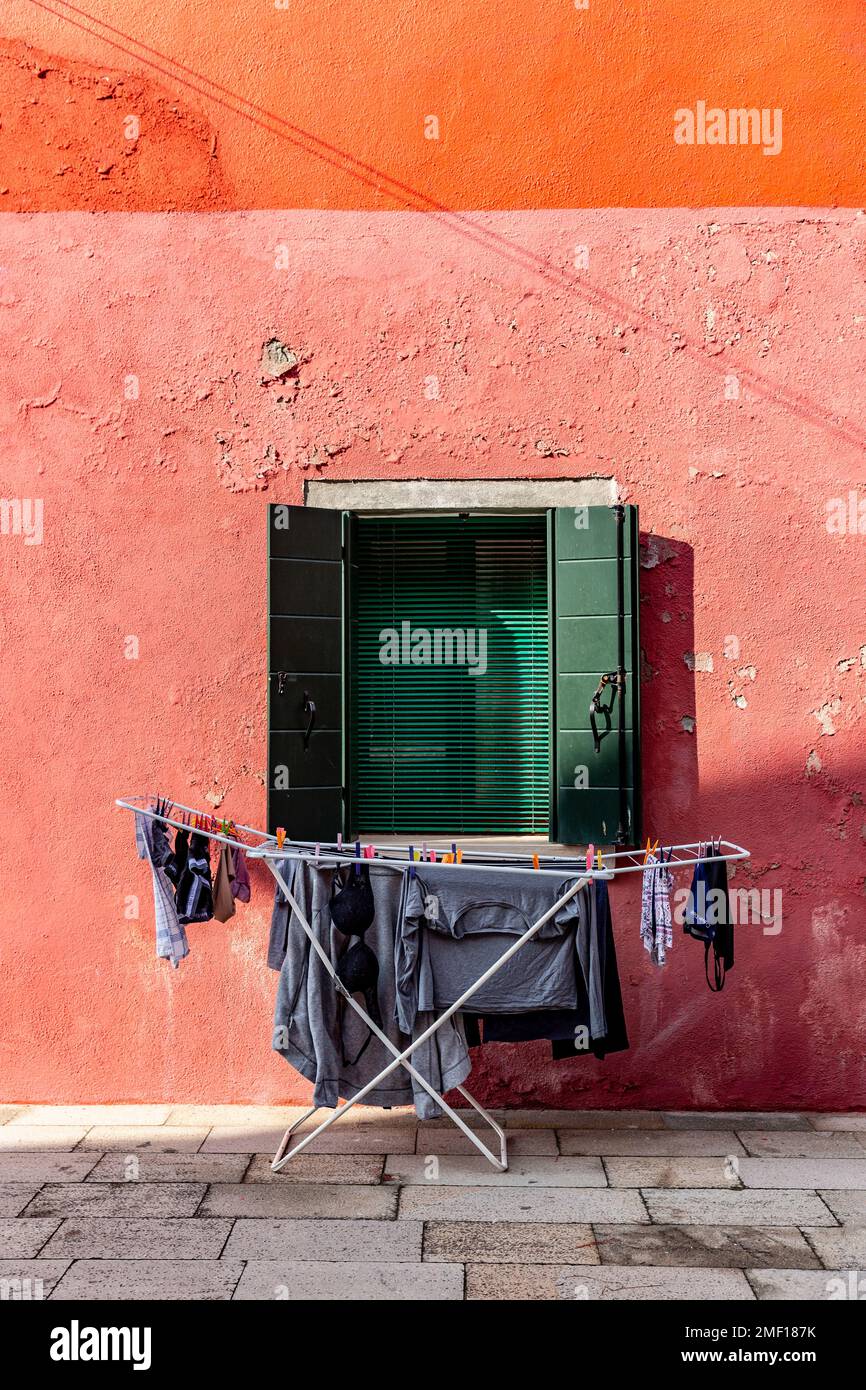 Wäscherei hängt auf einem Wäscheständer vor dem farbenfrohen Gebäude in Burano, Veneto, Italien. Stockfoto