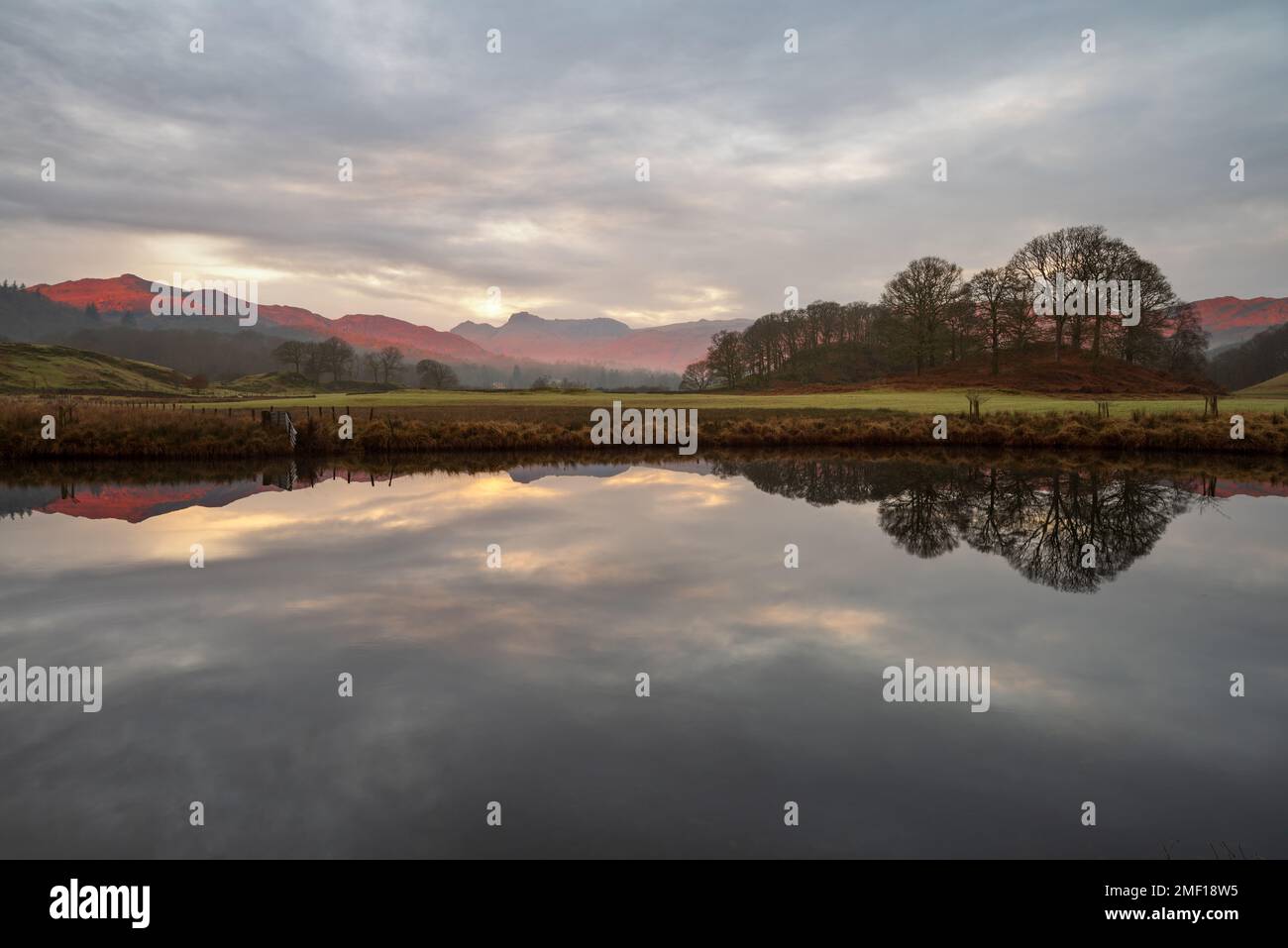 Wunderschönes Morgenlicht auf den Bergen von Cumbrian, das sich in einem ruhigen Fluss spiegelt, an einem ruhigen Morgen am Fluss Brathay im Lake District, Großbritannien. Stockfoto