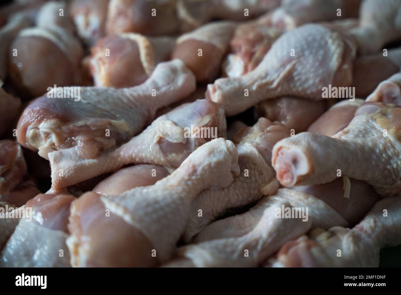 Rohe Hähnchenschenkel, großer Haufen auf dem Tischhintergrund Stockfoto