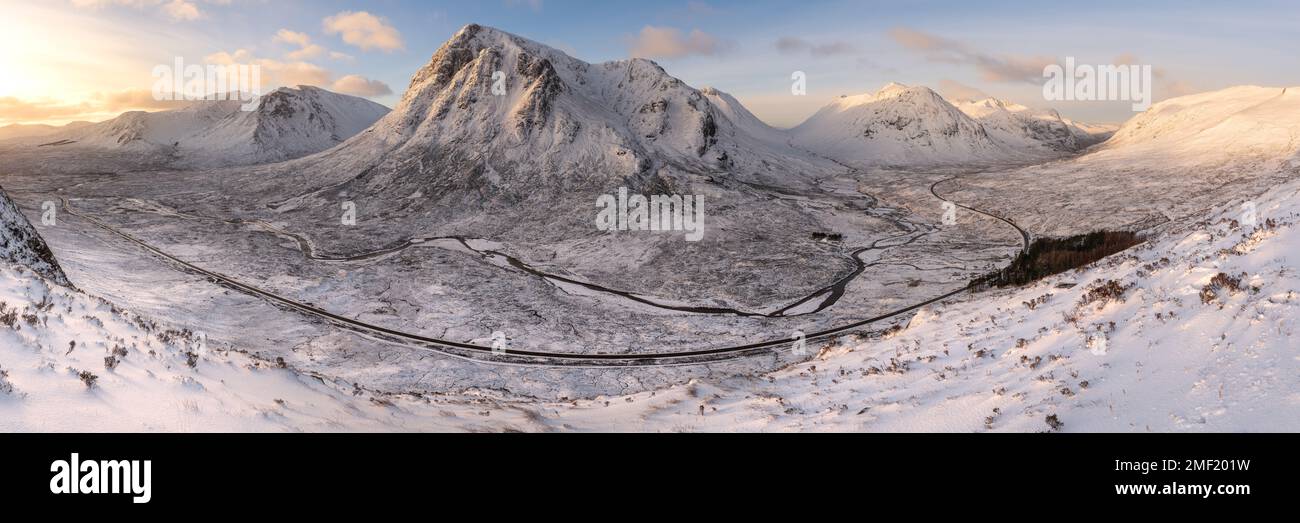 Glencoe Panorama an einem Wintermorgen mit Schnee auf den Bergen und langer Straße, die durch das Tal führt. Scottish Highlands, Großbritannien. Stockfoto
