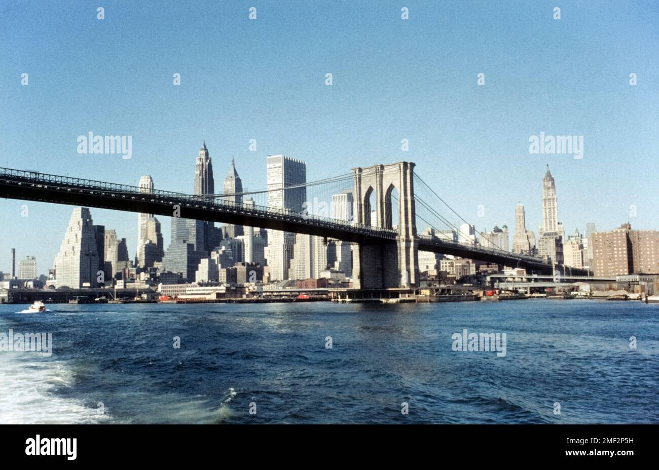 Brooklyn Bridge und die Skyline von Manhattan von einem Boot auf dem East River aus gesehen. New York City, USA, 1965 Stockfoto