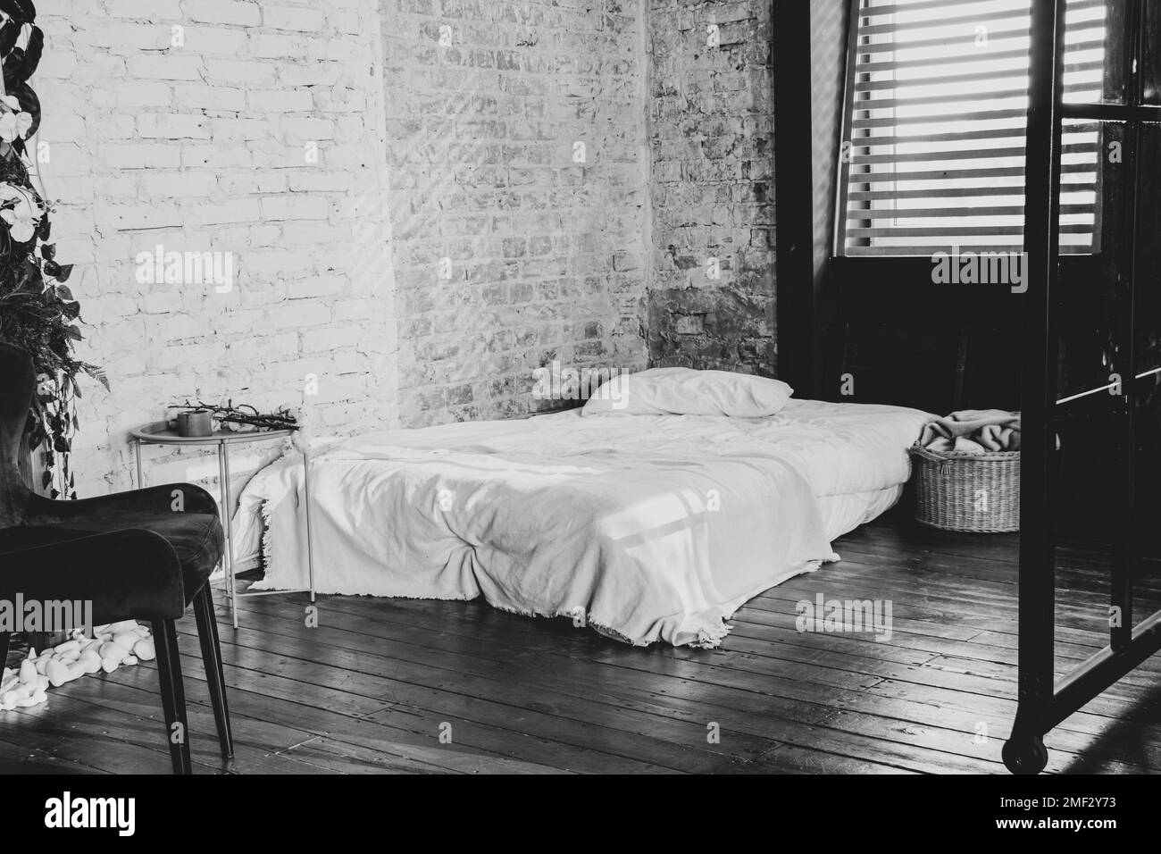Matratze auf dem Boden in der Nähe des Fensters, Bett im Schlafzimmer, Schlafzimmer innen in der Wohnung, stilvolles Schlafzimmer Stockfoto