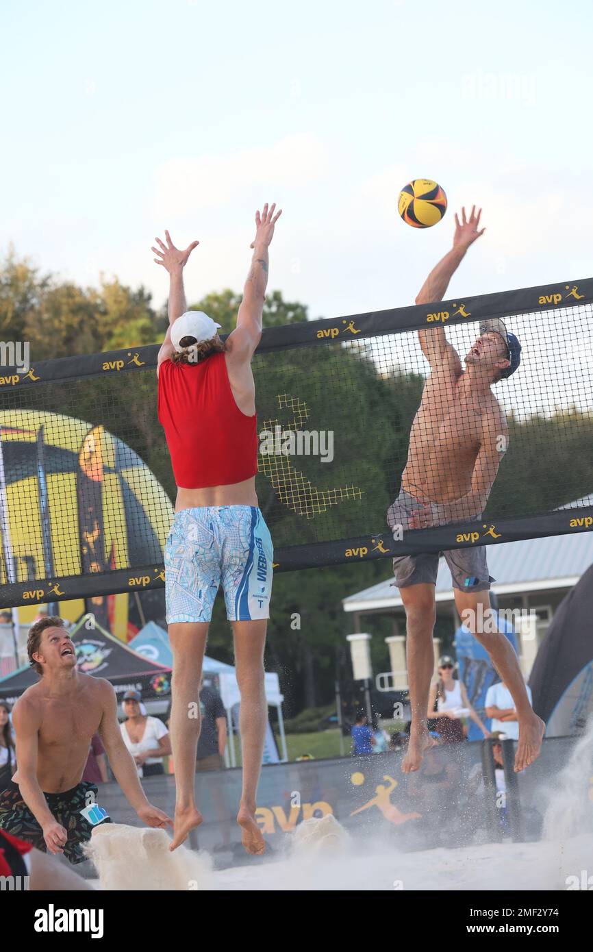 Avery Drost (rechts) spitzt den Ball, als Logan Webber (Mitte) versucht, ihn zu blockieren, während Chase Frishman (links) bei den AVP Central Florida Open at zusieht Stockfoto