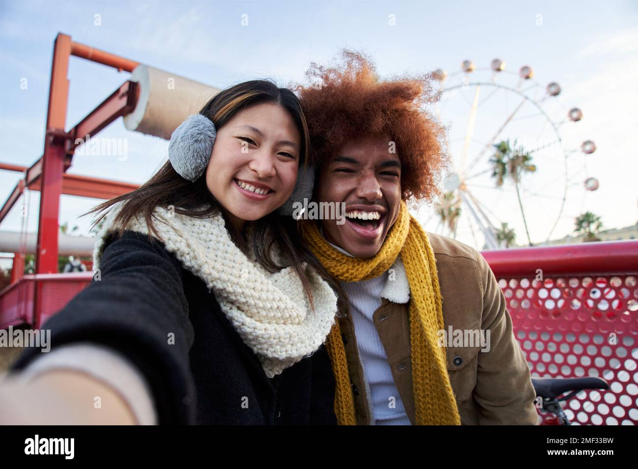 Ein junges Mischrasse-Paar in Winterkleidung macht ein Selfie im Freien. Stockfoto