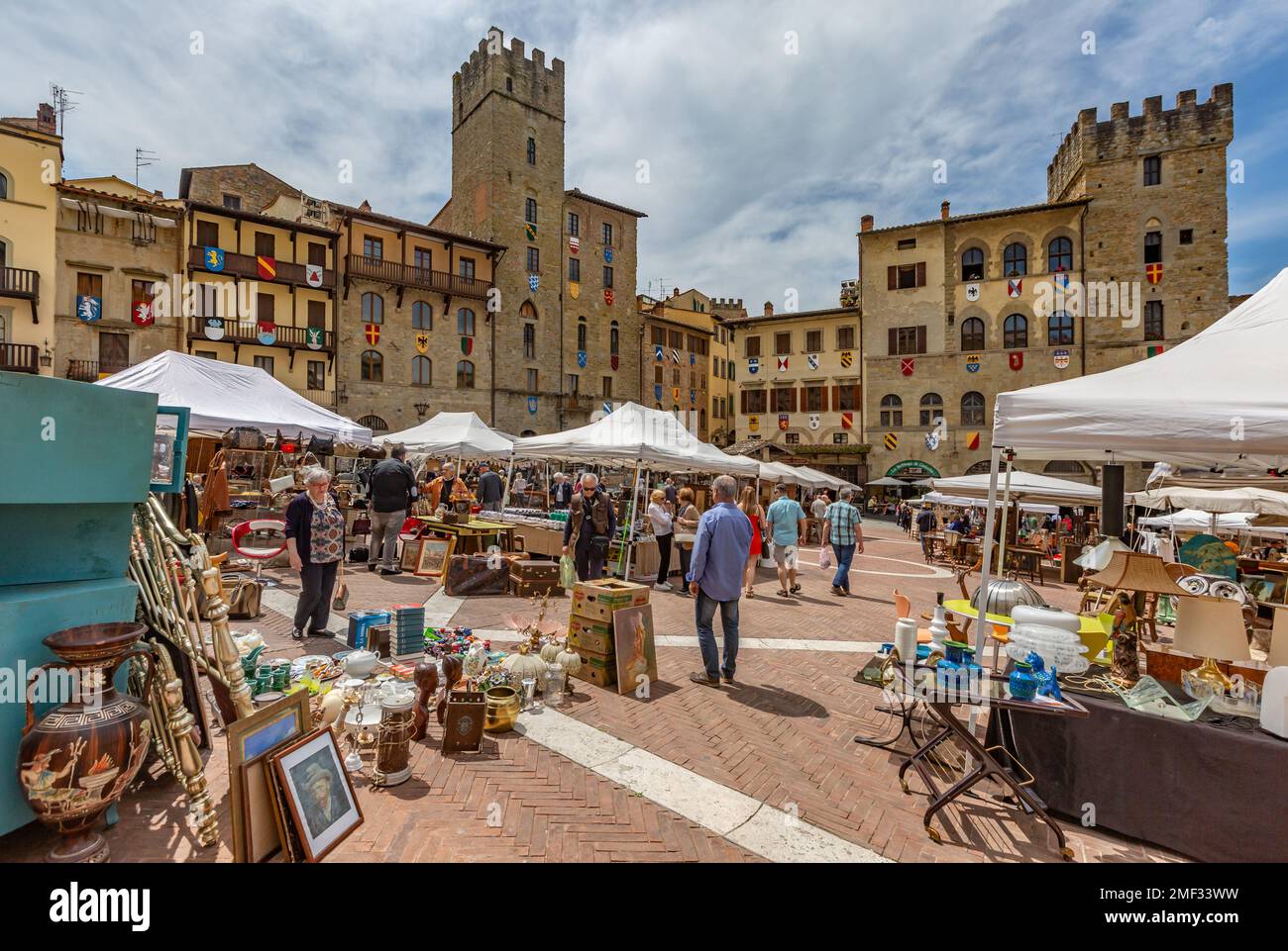 Besucher, die auf dem monatlichen Antiquitätenmarkt von Arezzo (Fiera Antiquaria) auf der Piazza Grande in der Toskana, Italien, einkaufen. Stockfoto