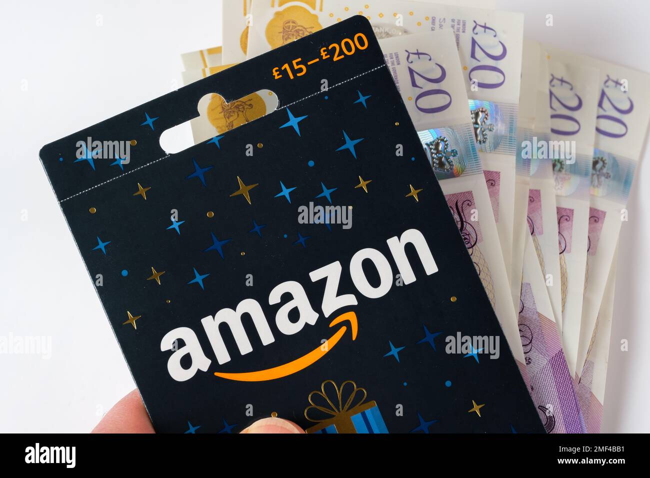 Amazon-Geschenkgutschein-Nahaufnahme und Bargeldeinbehalt in einer Hand. Stafford, Großbritannien, 24. Januar 2023 Stockfoto