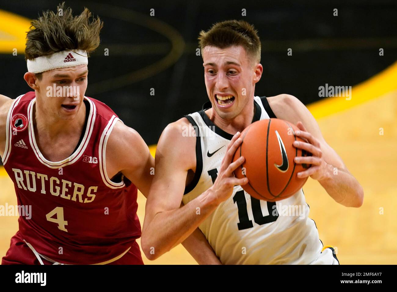 Iowa guard Joe Wieskamp drives to the basket past Rutgers guard Paul Mulcahy, left, during the second half of an NCAA college basketball game, Wednesday, Feb. 10, 2021, in Iowa City, Iowa. Iowa won 79-66. (AP Photo/Charlie Neibergall) Stockfoto