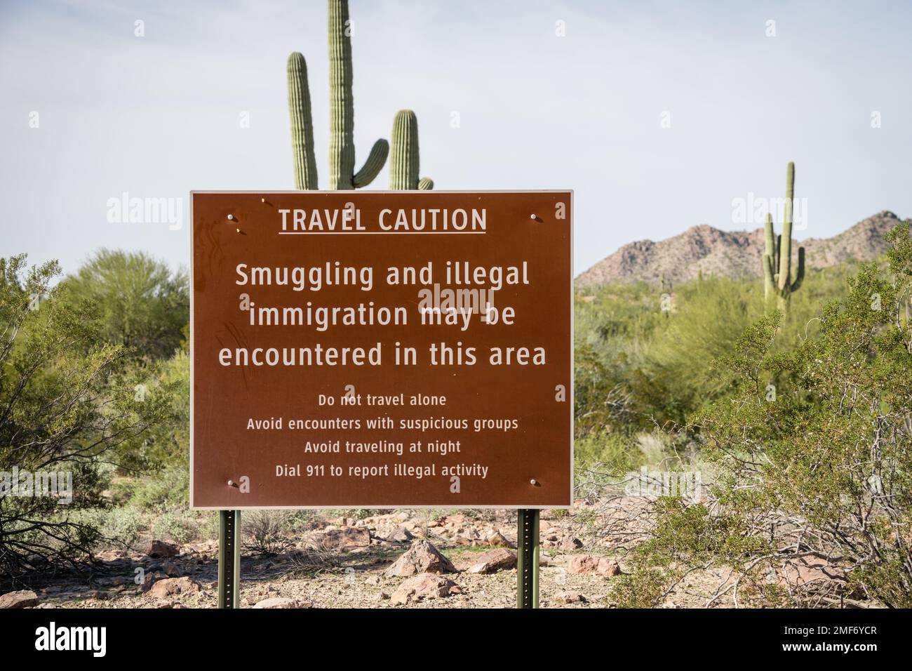 Schild nahe US - mexikanische Grenzmauer mit der Aufschrift Achtung Schmuggel und illegale Einwanderung in dieser Gegend - Arizona Stockfoto