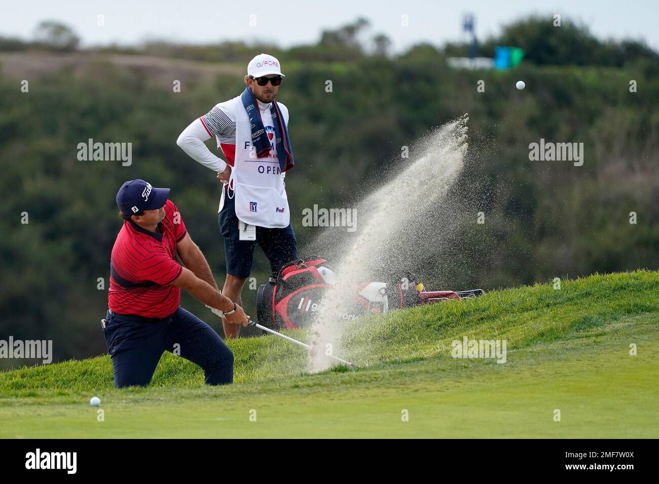 Patrick Reed hits from a bunker toward the 14th hole on the South