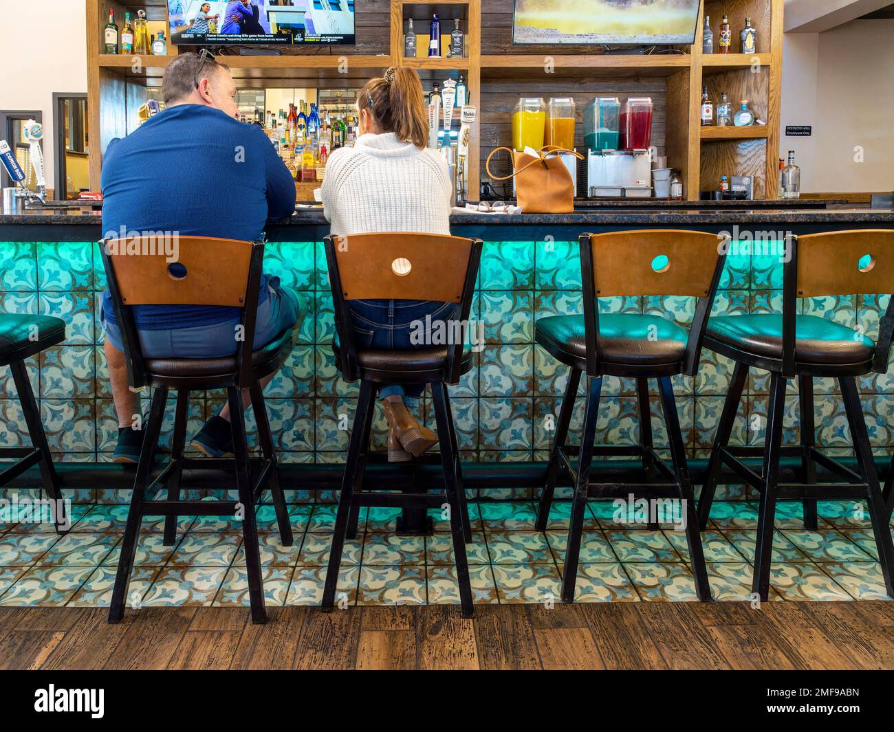 Menschen, ein Mann und eine Frau oder Ehemann und Ehefrau sitzen in einer farbenfrohen Bar in einem Restaurant oder einer Sportbar in der Pike Road, Alabama, USA. Stockfoto