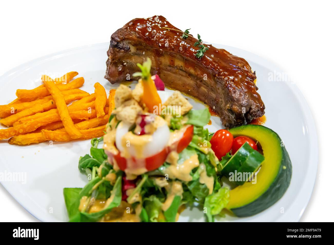 Gegrillte geräucherte Rippchen mit Barbecue-Sauce, Kartoffel- und Gemüsesalat auf weißer Isolation. Stockfoto