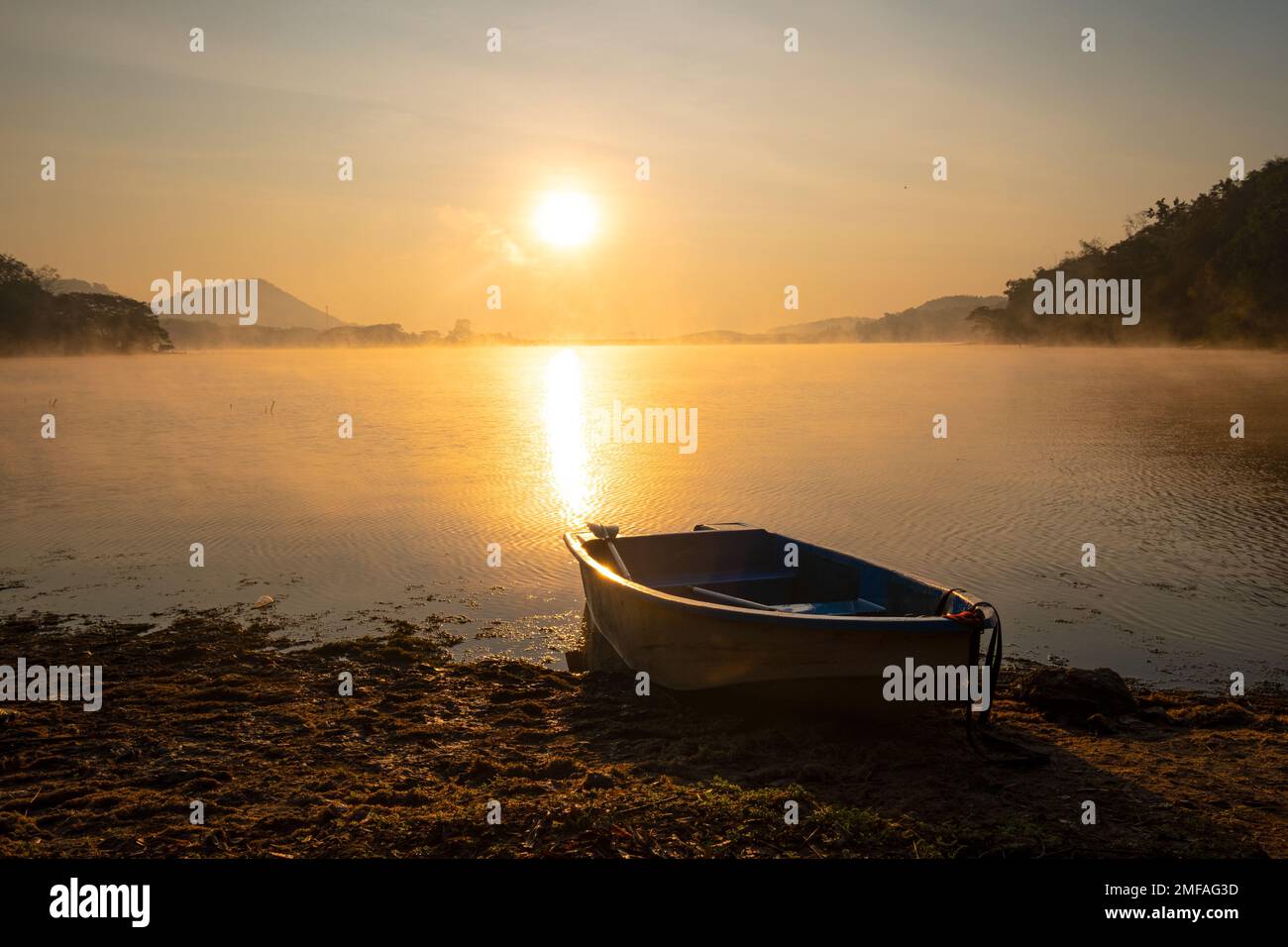 Das Boot war aus Fasern, er parkte während des Sonnenaufgangs am Rand eines Strandes im Reservoir. Im Harirak Forest Park Huai Nam man Reservoir Loei Thaila Stockfoto