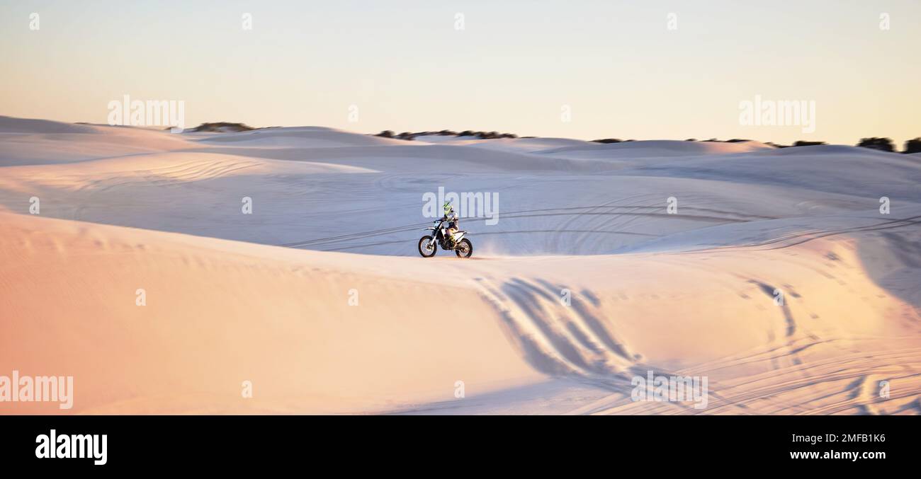 Wüste, Motorrad und Extremsport eines Mannes auf Sanddünen in Afrika, der sportlich fit ist. Herausforderung beim Fahren, Strandabenteuer und Radtour eines Stockfoto