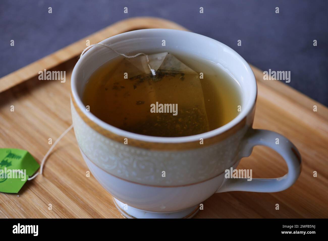 Grüner Tee mit Teebeutel auf Fliesen Hintergrund Stockfoto
