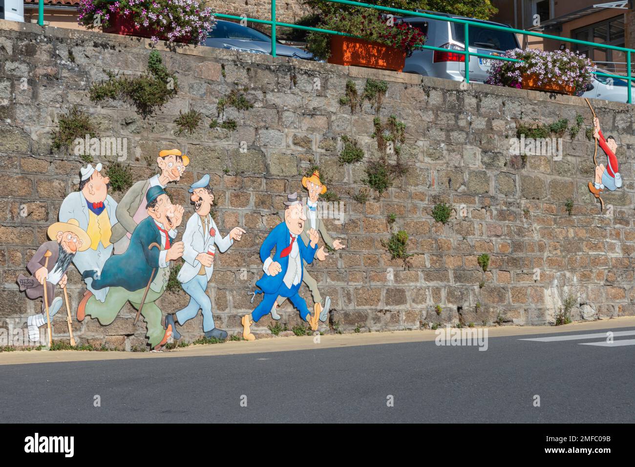 Humorvolle Wandmalereien auf einer Steinmauer im Dorf Vaux-en-Beaujolais, Frankreich Stockfoto