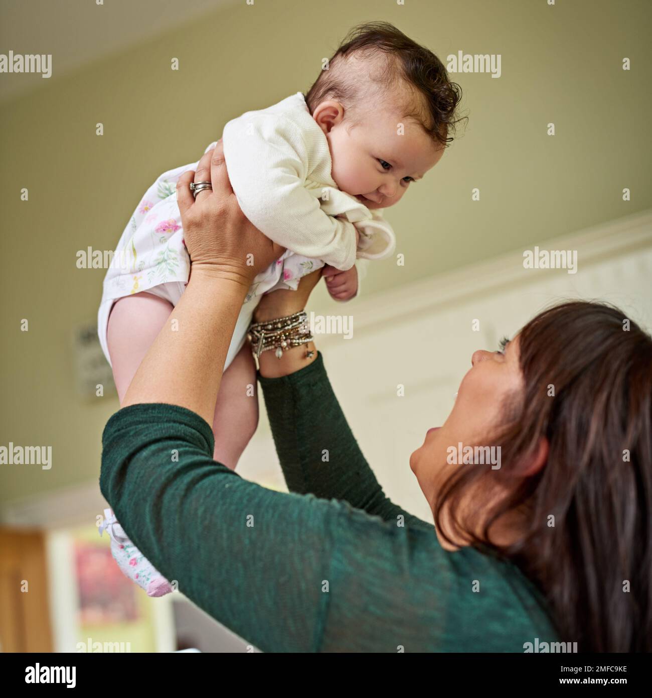 Moms größtes Bündel an Freude. Eine Mutter, die sich mit ihrer süßen kleinen Tochter zu Hause anfreundet. Stockfoto